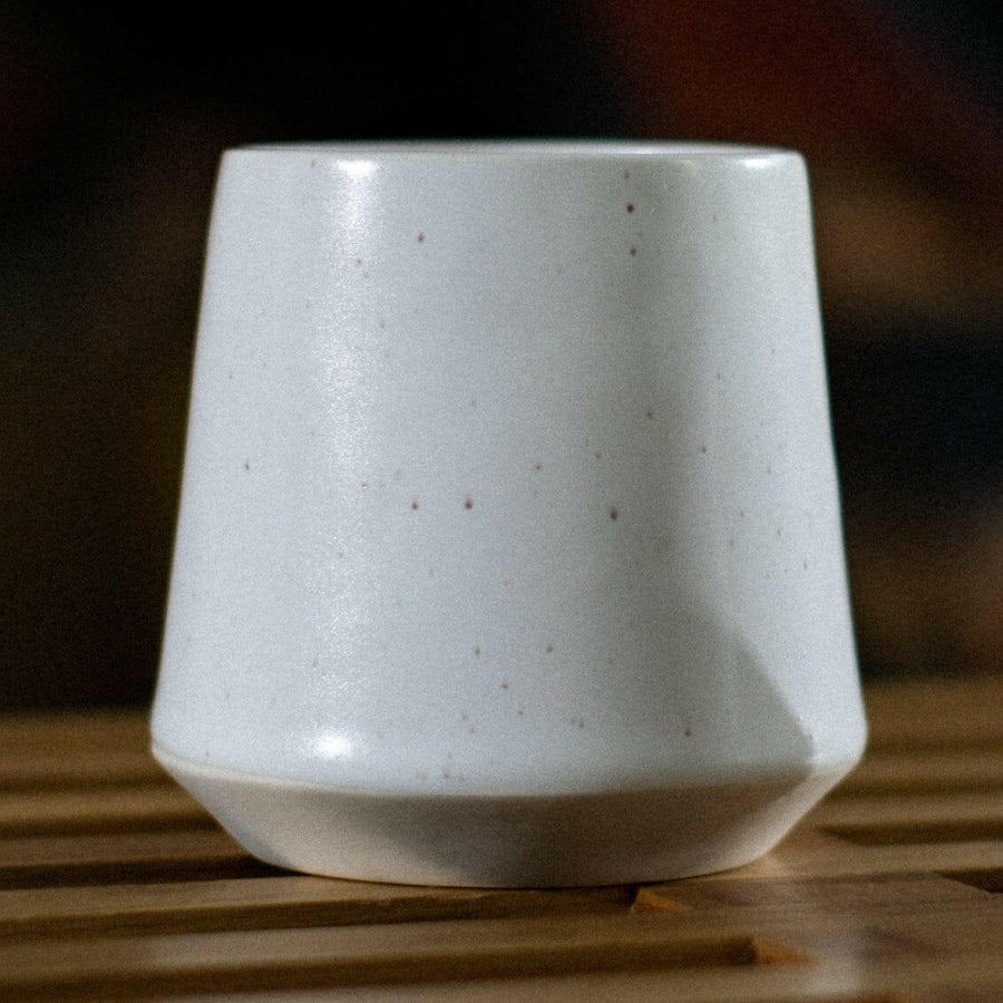 Elegant ceramic cups arranged neatly on a polished wooden table, perfect for morning coffee or tea rituals.